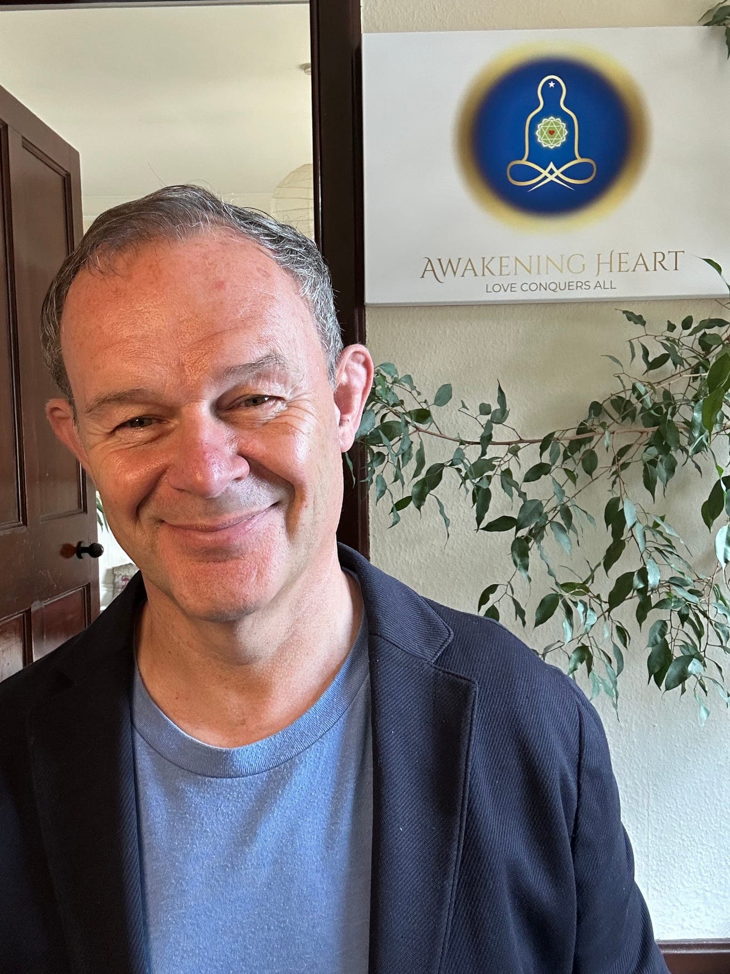 Andrew Cook beside the Awakening Heart logo